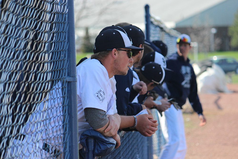 SSC Bulldog players watch on from the dugout