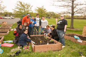 SSC students work in a garden for pollinators plant young plants with SSC Green's Alysia Robinette, the event’s coordinator