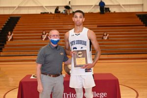 Photo of Bulldogs forward Deshawndre Washington is presented the Regional Tournament MVP Award by Harry McGinnis, Triton College Athletic Director.